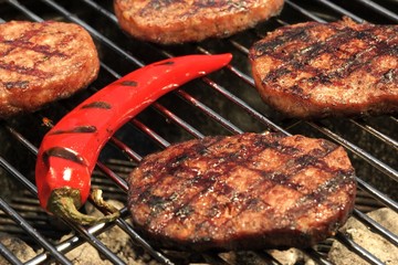 BBQ Hamburger Patties And Chili Pepper On The Hot Grill