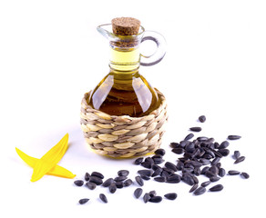 Decanter with sunflower oil izoltrovanny. Carafe oil and sunflower petals. Sunflower seeds are scattered.