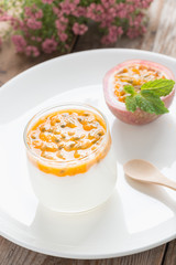 Yogurt with passion fruit on white plate.