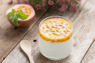 Fresh yogurt with passion fruit on wood table.
