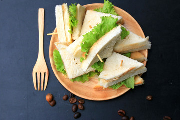 tuna sandwiches and hot coffee on black background