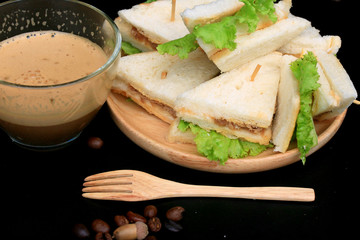 tuna sandwiches and hot coffee on black background