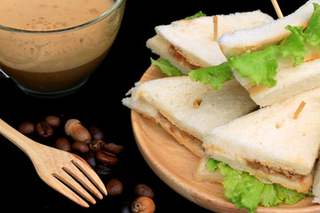 tuna sandwiches and hot coffee on black background
