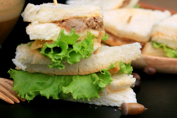 tuna sandwiches and hot coffee on black background