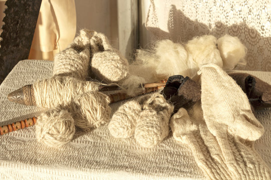 Antiguo uso y rueca de hilar, lana virgen de oveja y labores hechos a mano (calcetines y escarpines)