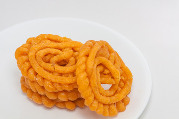 Three jalebis in a white plate