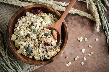 Tuinposter Oat and whole wheat grains flake in wooden bowl on wooden table © Kittiphan