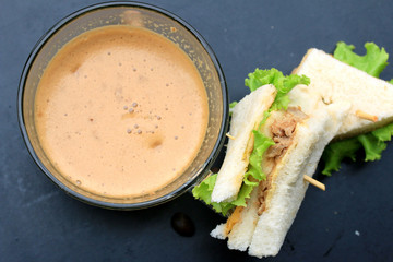 tuna sandwiches and hot coffee on black background
