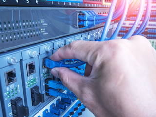 hand of administrator holding optic fiber cables with connectors