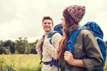 smiling couple with backpacks hiking