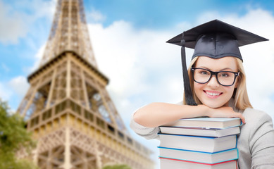 student in trencher with books over eiffel tower