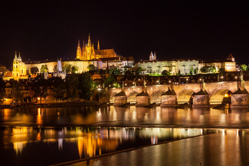 Fototapeta na wymiar View at night over the RiverVltava with Charles Bridge and the C