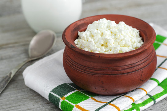 Crumbly homemade cottage cheese in a clay pot