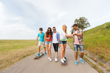 happy teenage friends with longboards outdoors