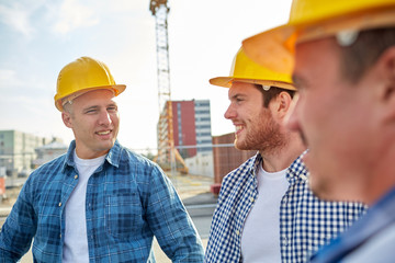 group of smiling builders in hardhats outdoors