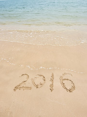 2016 written in sand, on tropical beach