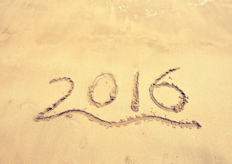 2016 written in sand, on tropical beach