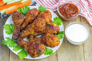 Roasted chicken served with celery and carrot sticks, blue cheese dressing and hot sauce