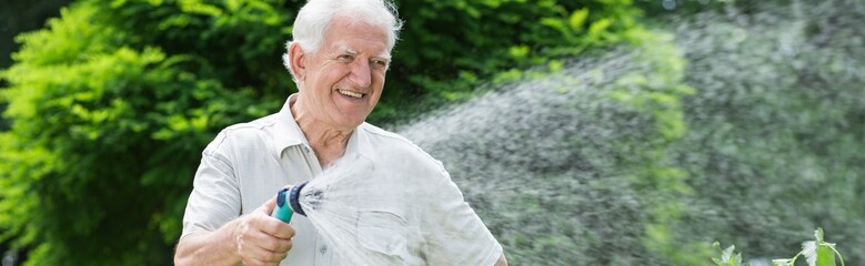 Happy gardener using garden hose