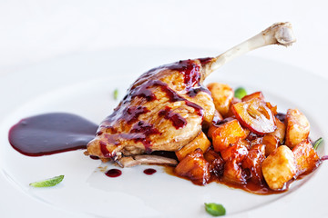 chicken with vegetables on white plate served topped with berry sauce