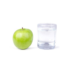 Glass of water and one green apple