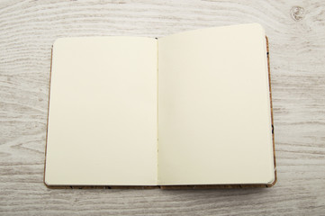 Open and blank notebook on wood texture.