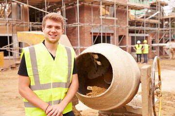 Portrait Of Worker On Building Site Mixing Cement