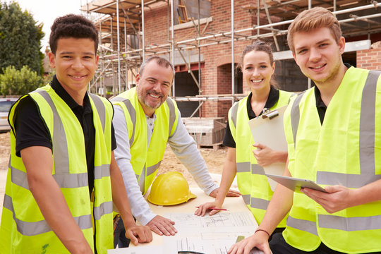 Portrait Of Builder On Building Site With Apprentices