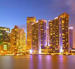 Fototapeta na wymiar City of Miami Florida, night skyline. Cityscape of residential and business buildings illuminated at sunset with reflection