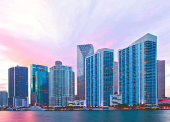 Fototapeta na wymiar City of Miami Florida, night skyline. Cityscape of residential and business buildings illuminated at sunset with reflection