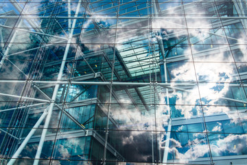 Sky and clouds reflected in the windows of an ecological and sustainable building.