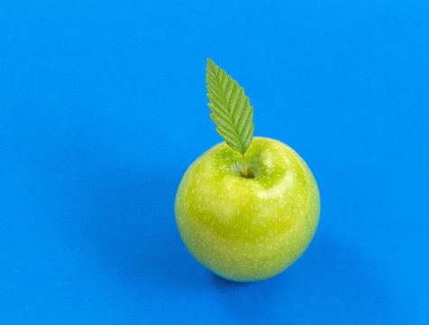 Ripe green apple on blue background