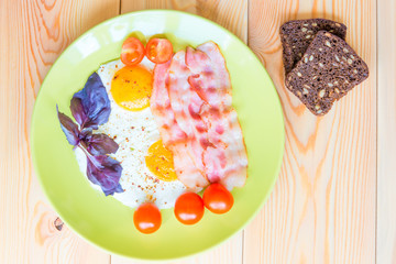 fried eggs with bacon and two slices of bread with grains