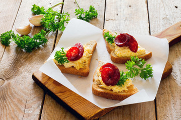 Bruschetta with cheese, garlic and jerked sausage on paper