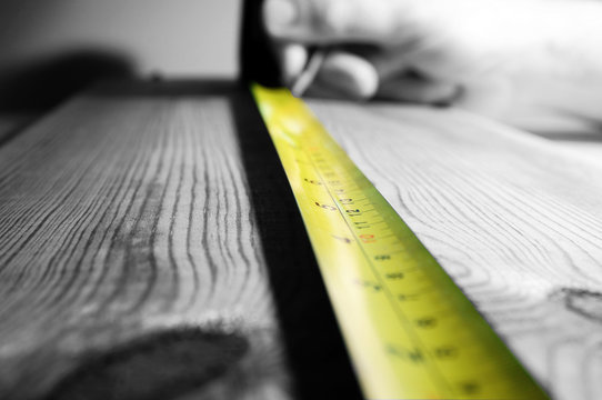 Tape measure wood.
Abstract image of a tape measure on a piece of wood.