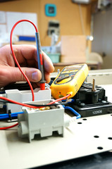 Testing wiring circuit.
Man at work testing wiring with a multi meter.