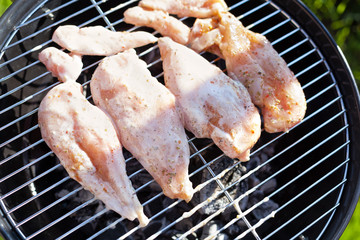 Raw chicken fillet breast cooking on barbeque grid