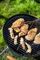 Raw chicken fillet breast cooking on barbeque grid