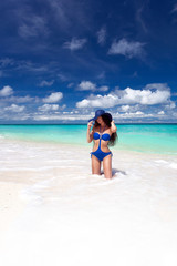 Fototapeta na wymiar Beautiful tan woman posing on tropical beach
