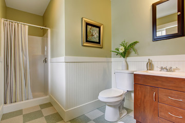 Fototapeta na wymiar Bathroom with checkered tile floor, and green white walls.