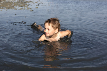 Kid lying in the black mud
