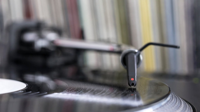 Dj stylus on spinning vinyl, record background
