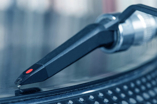 Dj stylus on spinning vinyl, record background