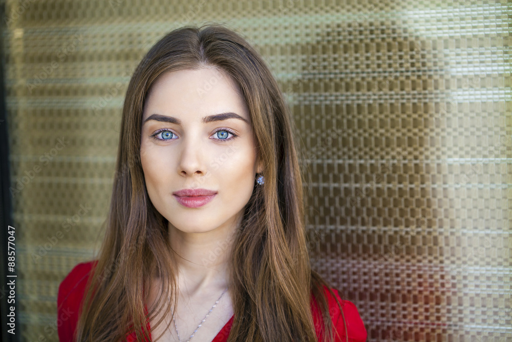 Wall mural portrait of a beautiful young girl in red shirt on the backgroun