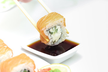 Sushi roll Philadelphia in chopsticks