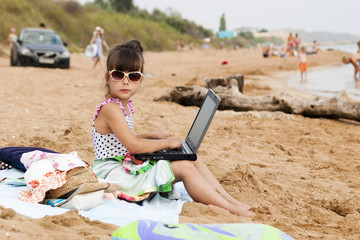 Девочка с ноутбуком на пляже
