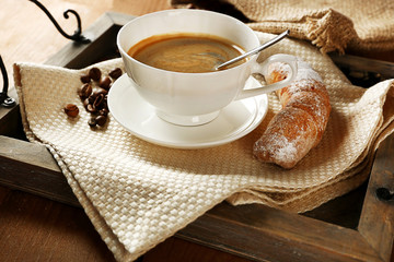 Cup of coffee with cookie on table, closeup
