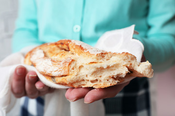 Woman holding tasty fresh bread, close up