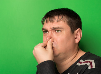 Caucasian man  pinches his nose