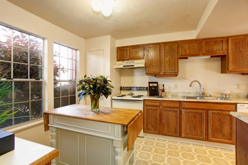 Traditional kitchen with tile floor, and small island.